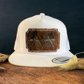 Cream snapback hat with deep espresso cowhide patch and blush pink hand-stitched border, branded with a registered cattle brand