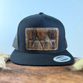 All-black trucker snapback hat with deep dark brindle cowhide patch and tan tonal stitched border, branded with a registered cattle brand