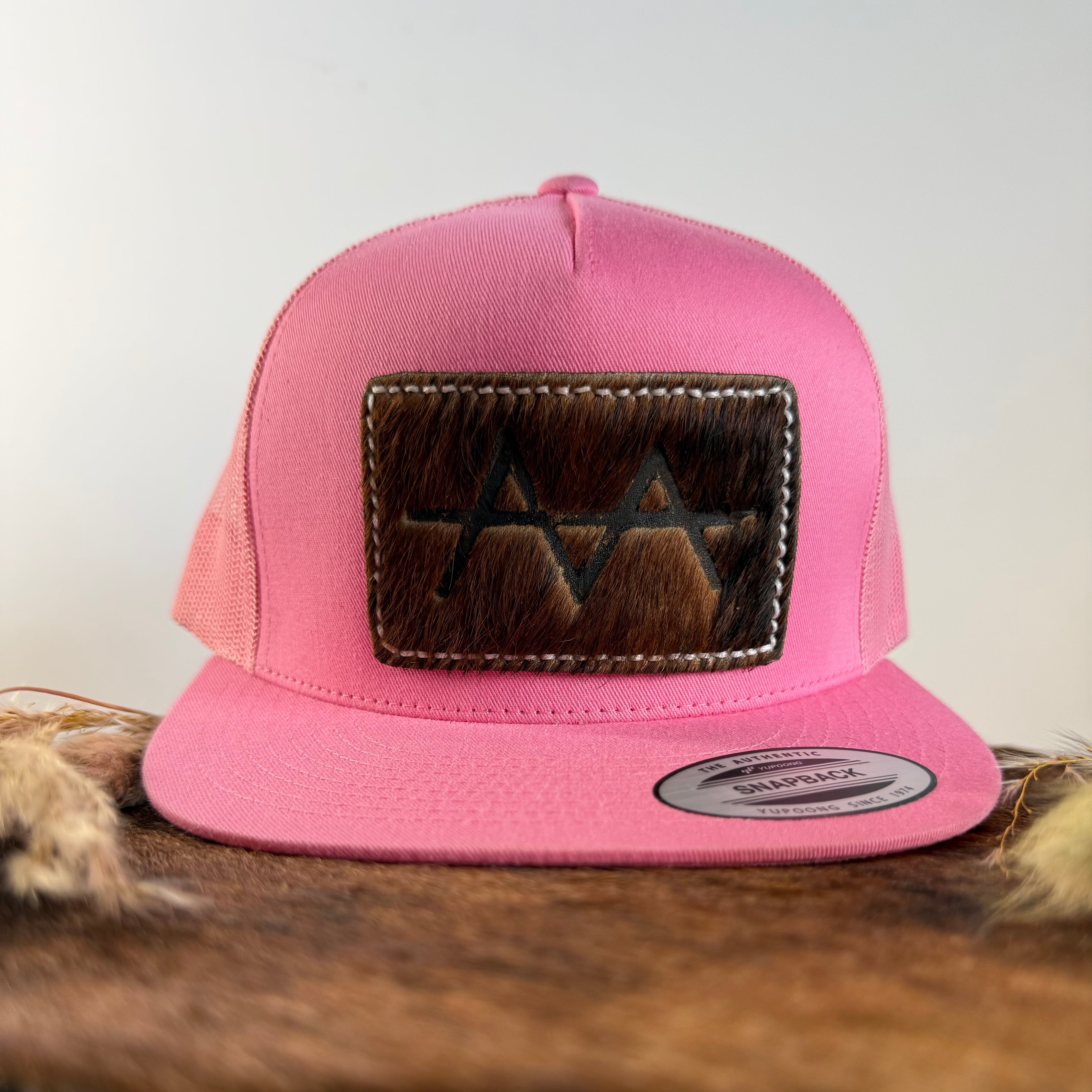 Pink snapback cap with cowhide leather patch, front view